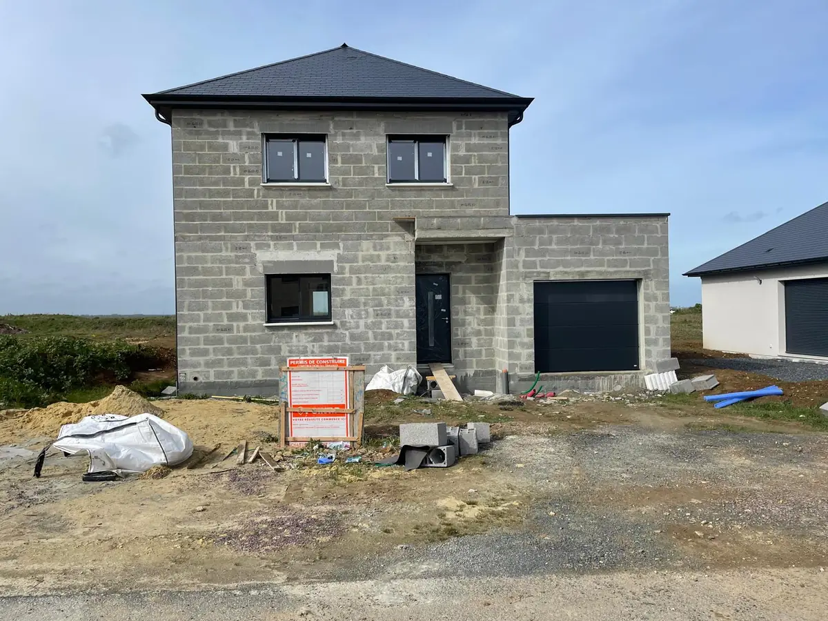 Élévation en parpaings d'une maison avec panneau de permis de construire