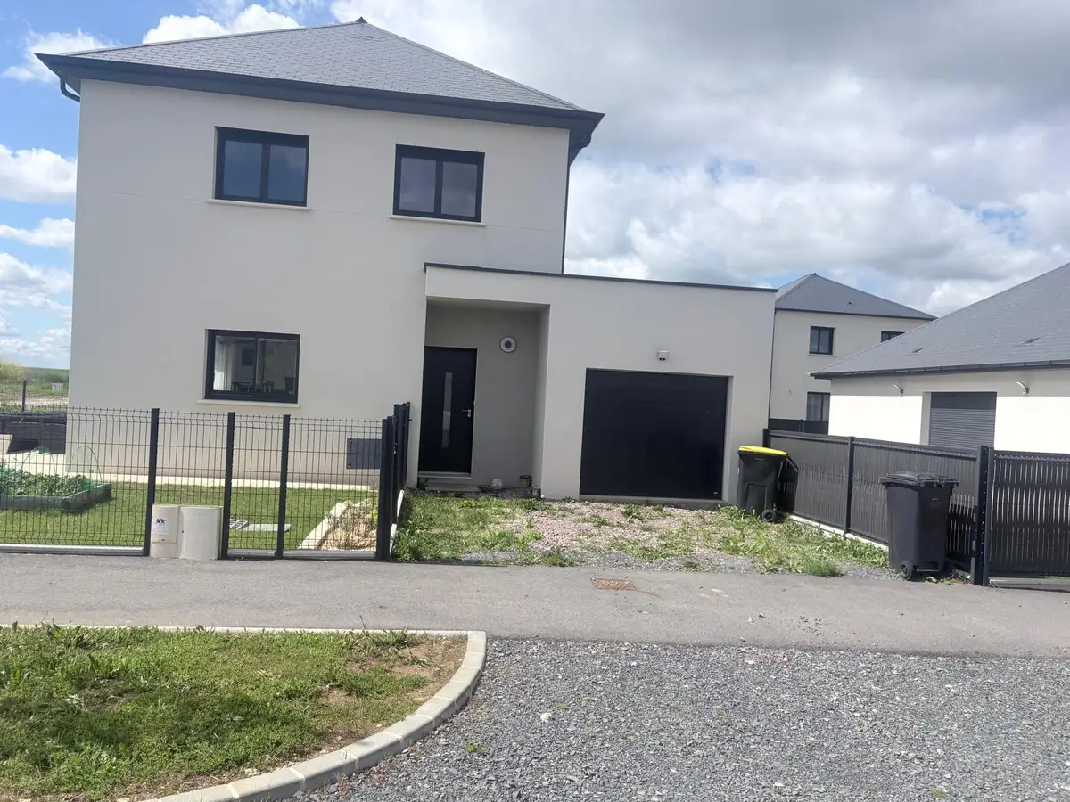 Maison individuelle livrée avec garage, enduit clair et toit en ardoise