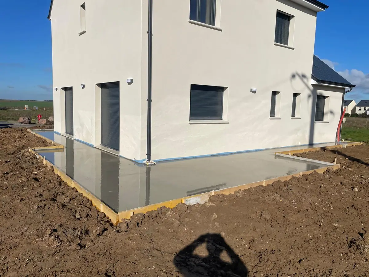 Terrasse en béton fraîchement coulée devant une maison
